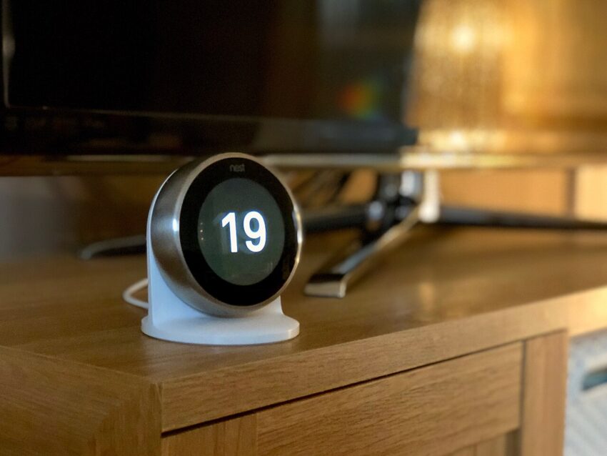 A round Google Nest smart thermostat displaying a temperature reading