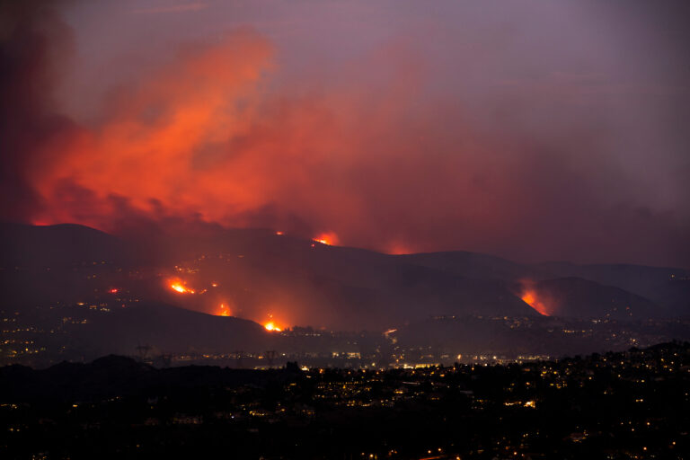A wildfire burning through California hills at night