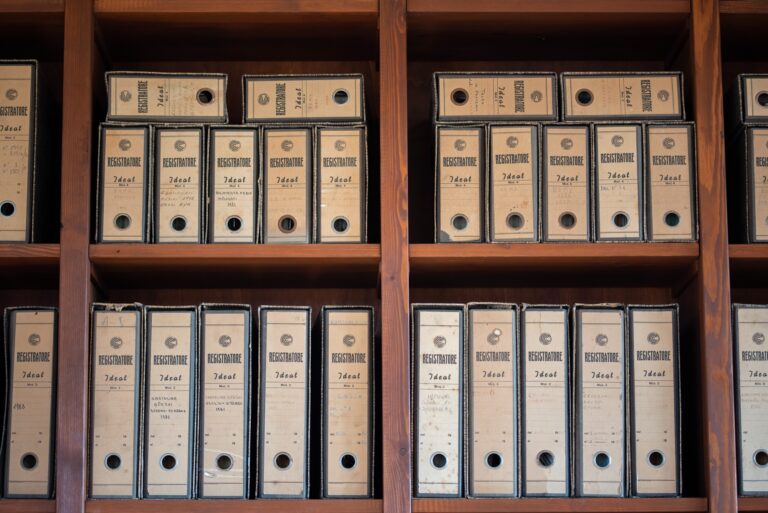 Cardboard archive boxes of documents on wooden shelves