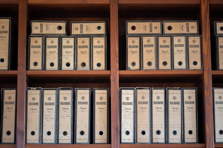 Cardboard archive boxes of documents on wooden shelves