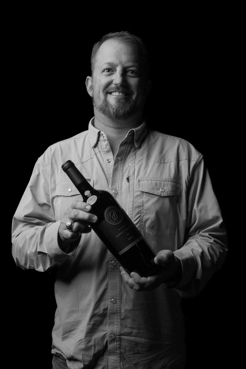 Jonathan Walters holding a bottle of Brassfield wine