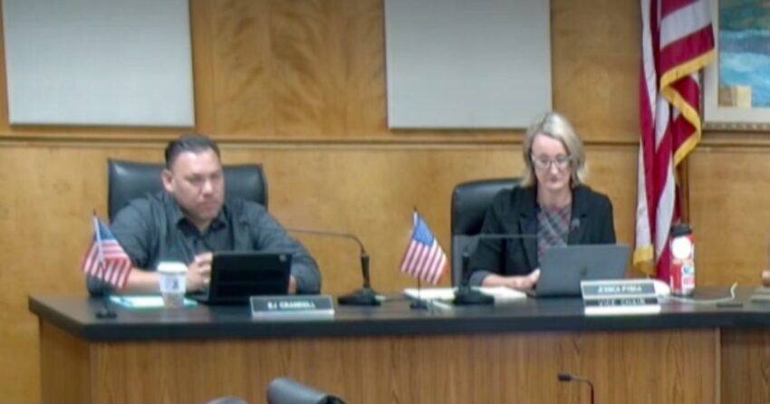 Two Lake County supervisors seated at the dais behind nameplates during a board meeting