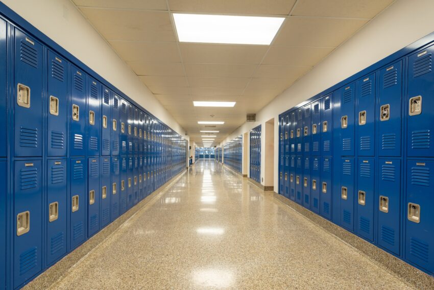An empty school hallway lined with blue lockers